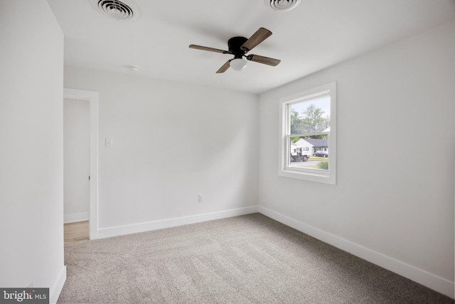 carpeted empty room with a ceiling fan and baseboards