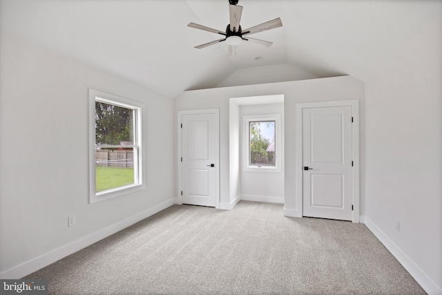 unfurnished bedroom featuring carpet flooring, vaulted ceiling, and baseboards
