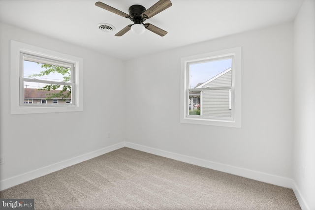 carpeted empty room with baseboards and a ceiling fan