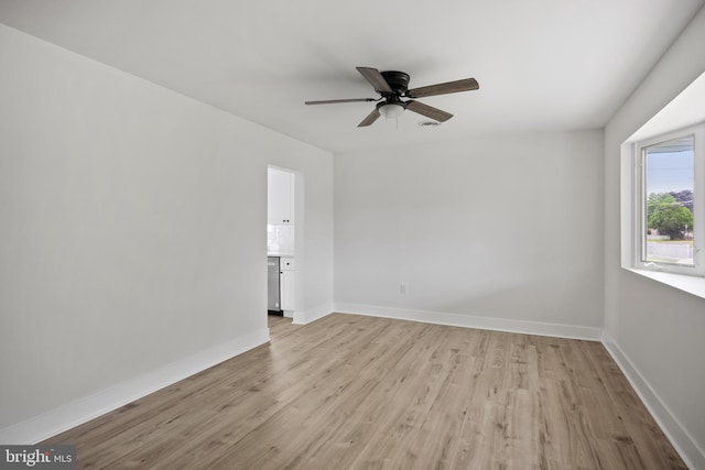 unfurnished room with light wood-style floors, ceiling fan, and baseboards