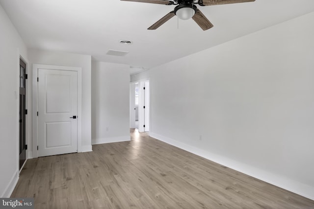 spare room featuring ceiling fan, light wood-style floors, and baseboards