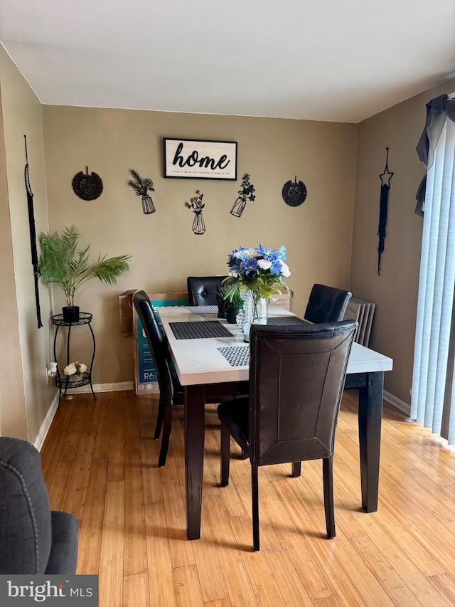 dining room featuring light wood-style floors and baseboards