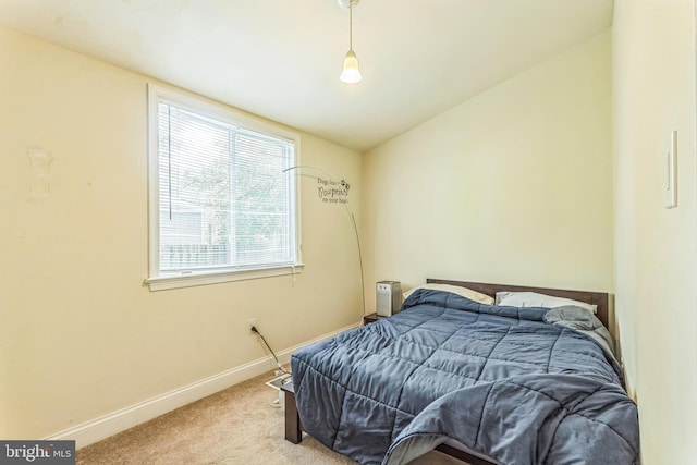 carpeted bedroom featuring baseboards and lofted ceiling
