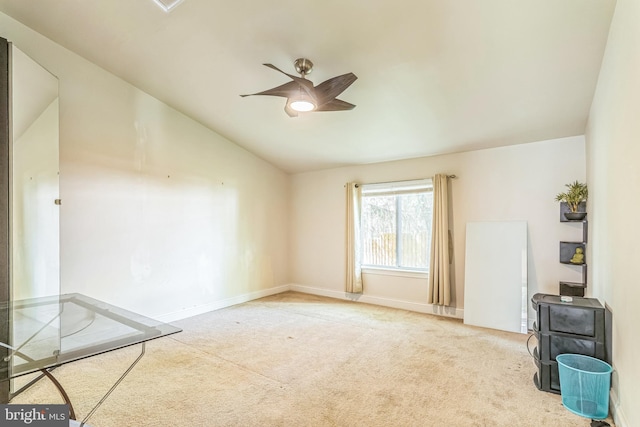 carpeted spare room with lofted ceiling, a ceiling fan, and baseboards