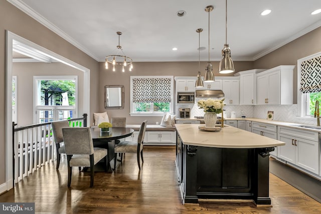 5526 Macarthur Blvd NW, Washington, DC 20016 - kitchen featuring light countertops, white cabinets, backsplash, stainless steel microwave, and a kitchen island