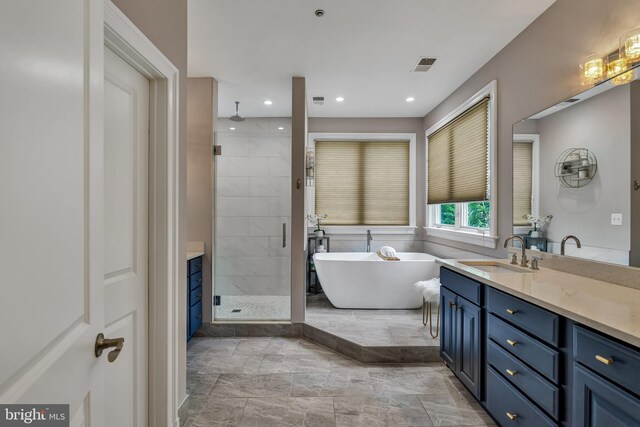 5526 Macarthur Blvd NW, Washington, DC 20016 - full bathroom with a shower stall, marble look tiles, vanity, a freestanding tub, and recessed lighting