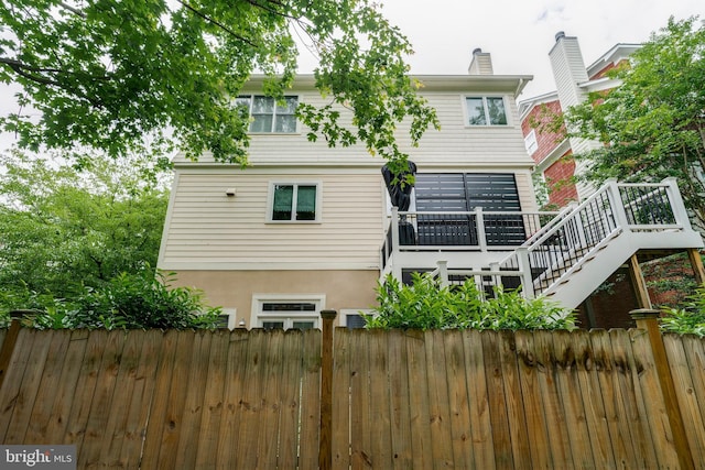 5526 Macarthur Blvd NW, Washington, DC 20016 - rear view of house featuring stairway, a wooden deck, a chimney, and stucco siding