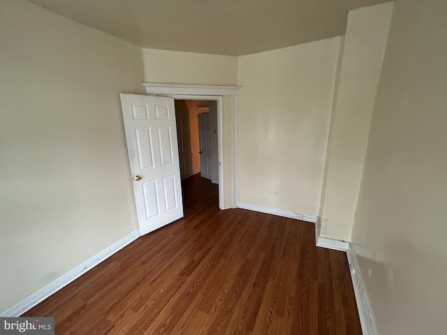 empty room with wood finished floors and baseboards