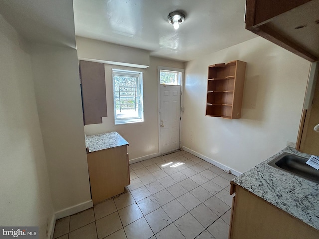 foyer with baseboards and light tile patterned flooring