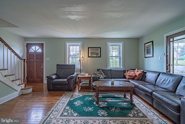 living area featuring wood finished floors, stairs, and baseboards