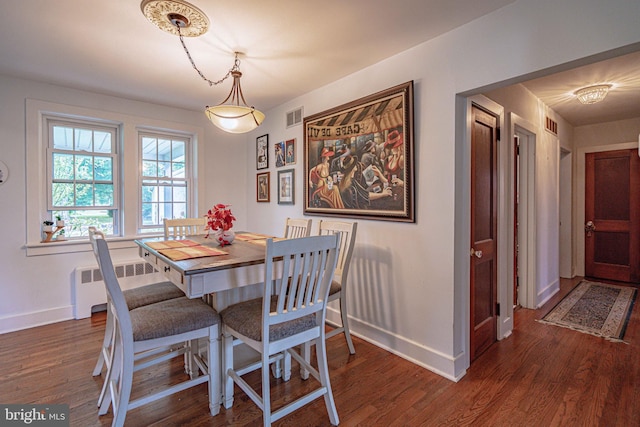dining room with radiator, baseboards, and wood finished floors