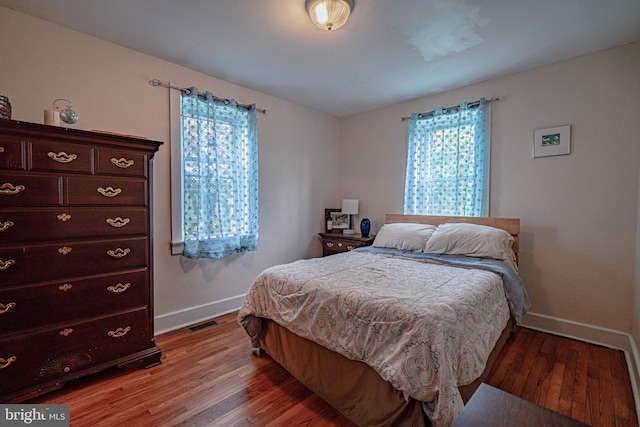 bedroom featuring baseboards and light wood finished floors