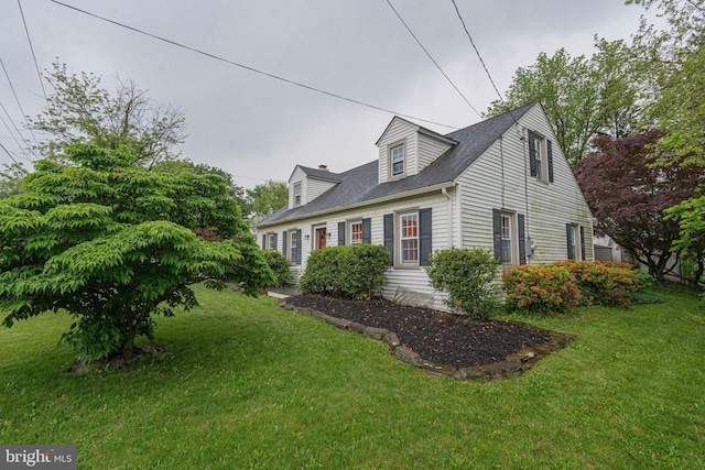 cape cod-style house with a front yard