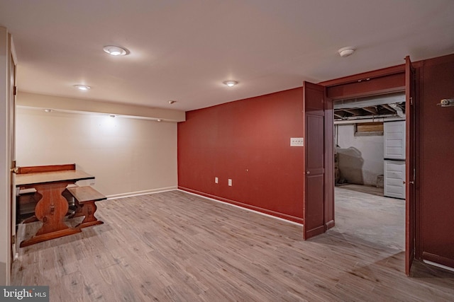 finished below grade area featuring wood finished floors and baseboards