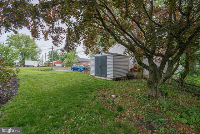 view of grassy yard featuring a storage unit and an outbuilding