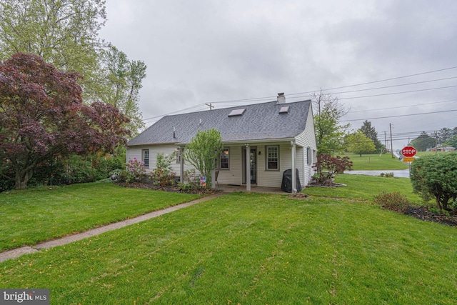 rear view of property featuring a yard, roof with shingles, and a chimney