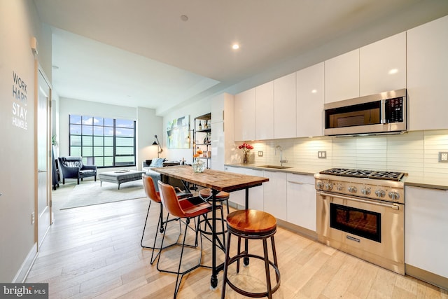 45 Sutton Sq SW Unit Ph11, Washington, DC 20024 - kitchen with appliances with stainless steel finishes, light wood-style flooring, a sink, white cabinetry, and recessed lighting