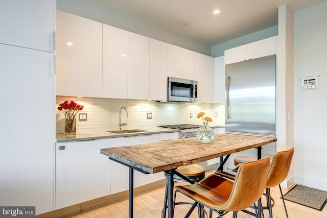 45 Sutton Sq SW Unit Ph11, Washington, DC 20024 - kitchen with a sink, appliances with stainless steel finishes, light wood-style floors, backsplash, and recessed lighting
