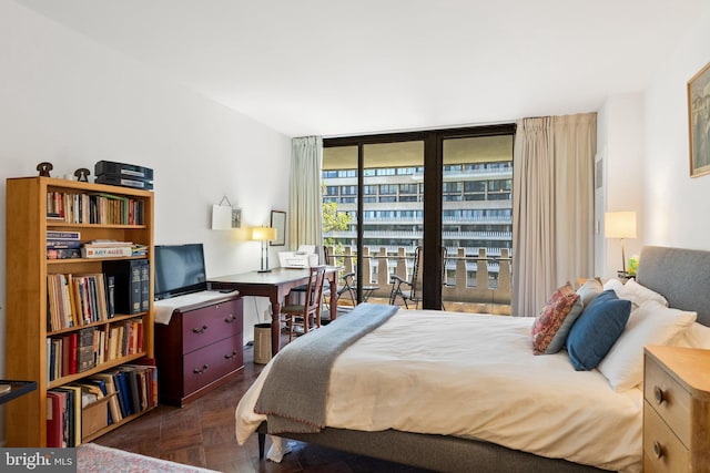 bedroom featuring expansive windows and a desk