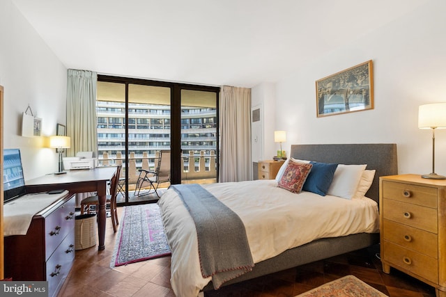 bedroom with expansive windows and an office area