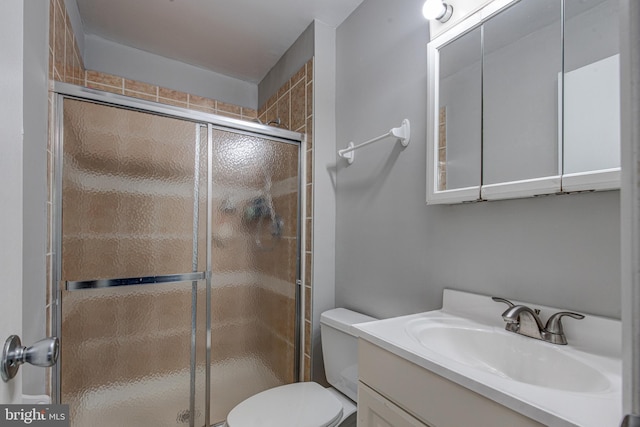 bathroom featuring a stall shower, toilet, and vanity