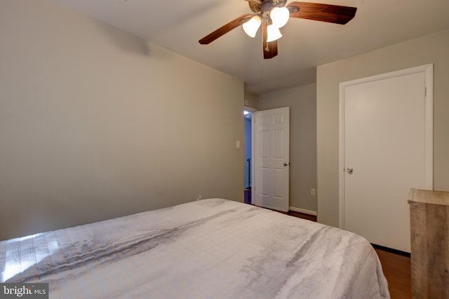 bedroom with wood finished floors, a ceiling fan, and baseboards