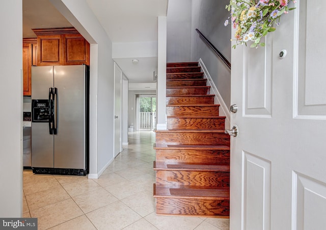 stairway featuring tile patterned flooring and baseboards
