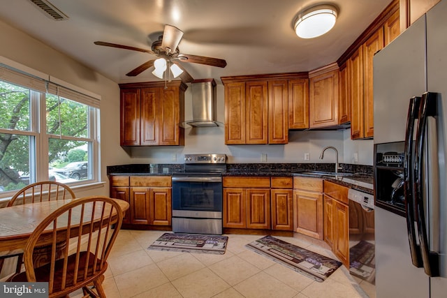 kitchen featuring fridge with ice dispenser, wall chimney exhaust hood, stainless steel range with electric cooktop, a sink, and brown cabinetry