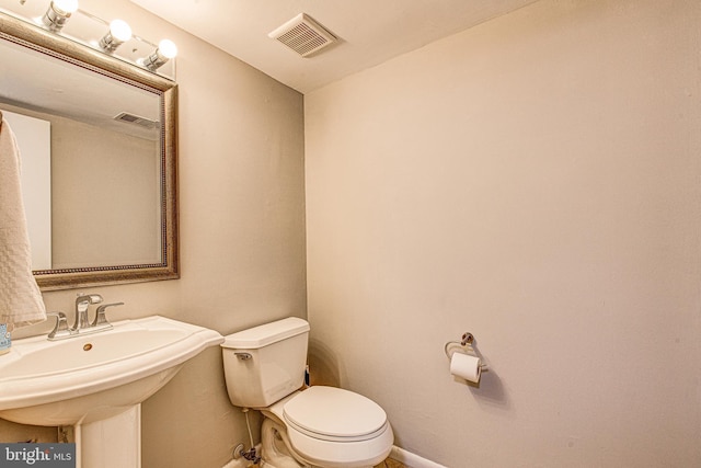 half bathroom featuring toilet and baseboards