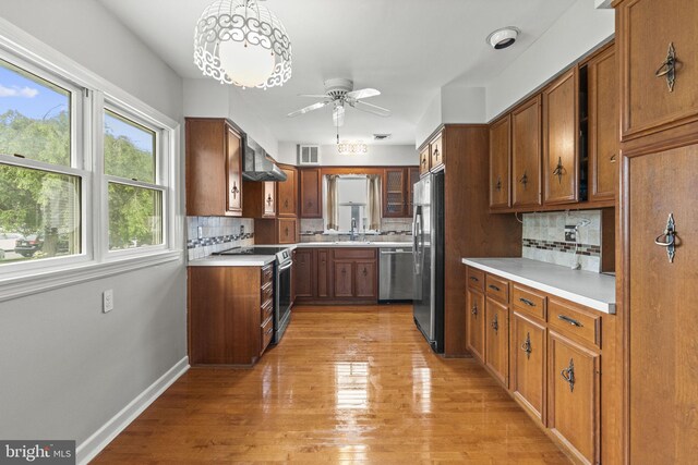 15 Renee, Lawrence Township, NJ 08648 - kitchen featuring appliances with stainless steel finishes, brown cabinets, a ceiling fan, light wood finished floors, and decorative backsplash