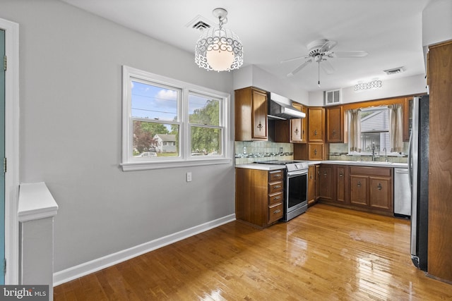 15 Renee, Lawrence Township, NJ 08648 - kitchen featuring stainless steel appliances, wall chimney range hood, a sink, baseboards, and plenty of natural light