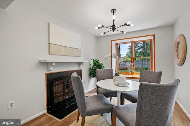 18165 Metz Dr, Germantown, MD 20874 - dining space featuring wood finished floors, a chandelier, baseboards, and a tile fireplace