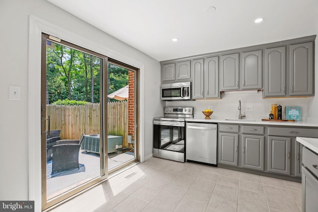 18165 Metz Dr, Germantown, MD 20874 - kitchen featuring gray cabinetry, stainless steel appliances, a sink, light countertops, and recessed lighting