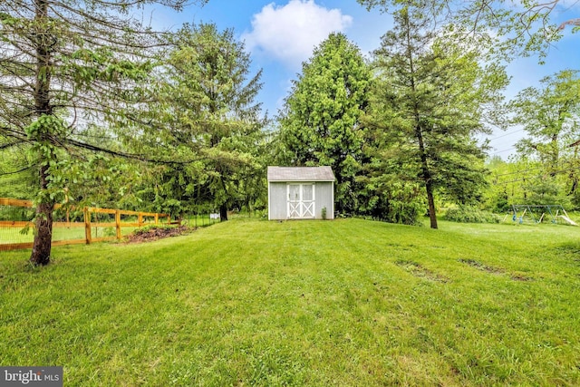 view of green lawn with a storage shed and an outdoor structure