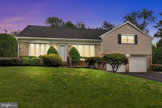 669 Worthington Dr, Warminster, PA 18974 - view of front of house with stone siding, asphalt driveway, a yard, and a garage