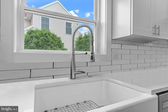 669 Worthington Dr, Warminster, PA 18974 - kitchen view of a sink, decorative backsplash, white cabinets, and light stone counters