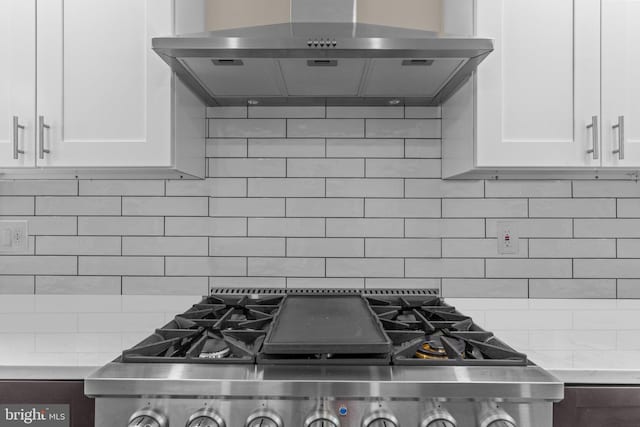 669 Worthington Dr, Warminster, PA 18974 - kitchen featuring wall chimney range hood, stove, tasteful backsplash, and white cabinetry
