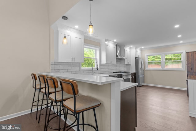 669 Worthington Dr, Warminster, PA 18974 - kitchen with appliances with stainless steel finishes, wall chimney range hood, baseboards, backsplash, and ornamental molding