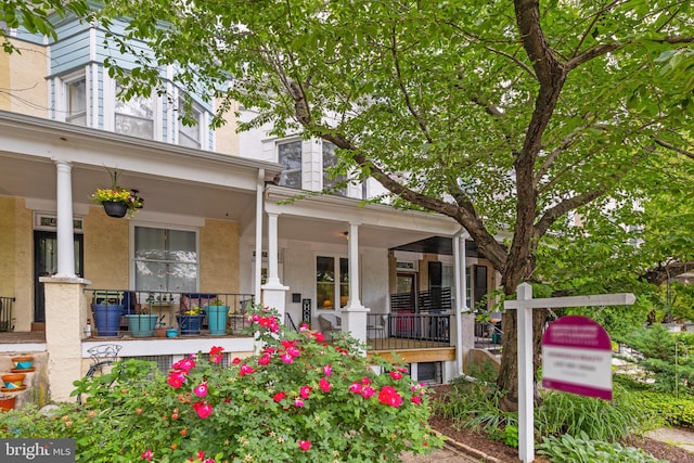 property entrance with a porch and stucco siding