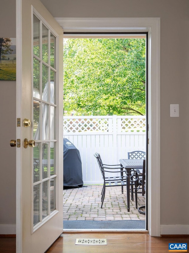 doorway to outside featuring baseboards and wood finished floors