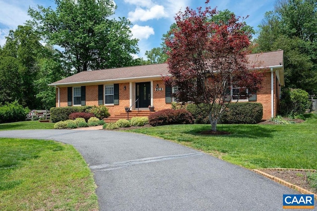 ranch-style house with brick siding, a front yard, and asphalt driveway