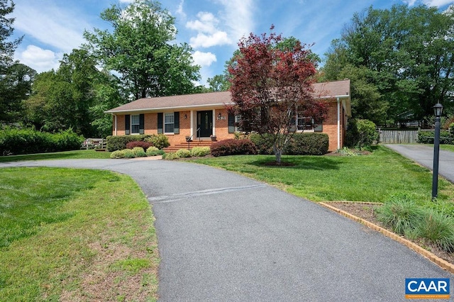 single story home with driveway and brick siding