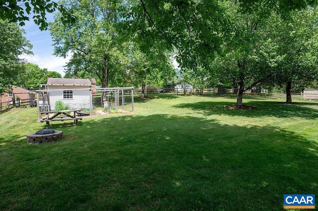view of yard featuring a fire pit and an outdoor structure