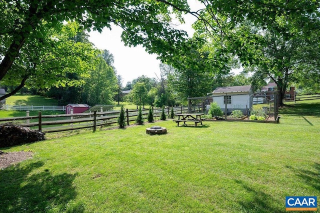 view of yard with an outdoor fire pit and an outbuilding