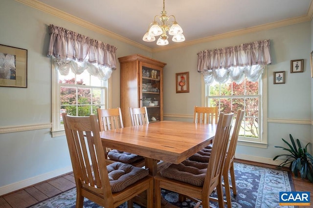 dining space with a chandelier, baseboards, wood finished floors, ornamental molding, and healthy amount of natural light