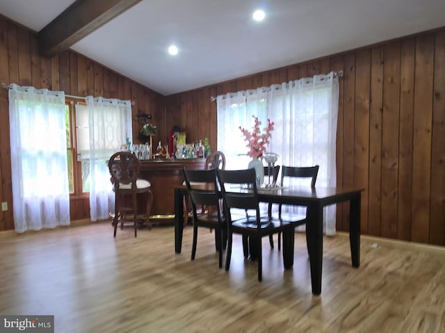 dining space featuring wood finished floors and wood walls