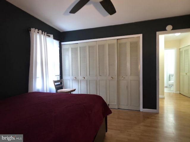 bedroom with wood finished floors, ceiling fan, baseboards, and a closet