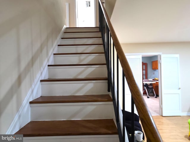 stairs featuring wood finished floors