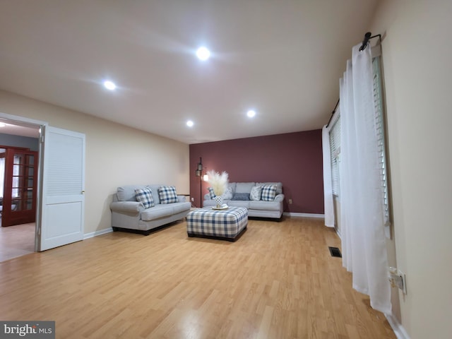 living room featuring light wood-style flooring, recessed lighting, and baseboards