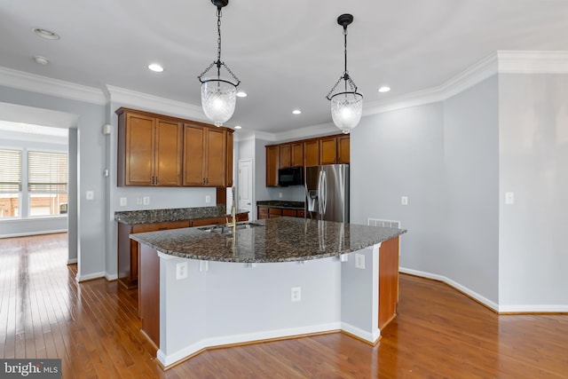 23462 Twin Falls Ter, Ashburn, VA 20148 - kitchen with stainless steel refrigerator with ice dispenser, black microwave, ornamental molding, a center island with sink, and dark wood-type flooring